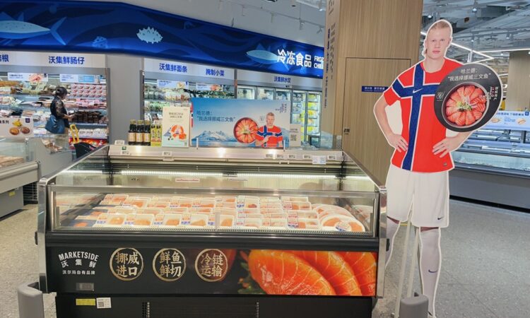 Expositores publicitarios de Erling Haaland promocionando salmón noruego en la sección de pescadería de un supermercado en China.