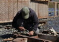 Trabajador realiza labores manuales en una zona costera de la Región de Los Lagos