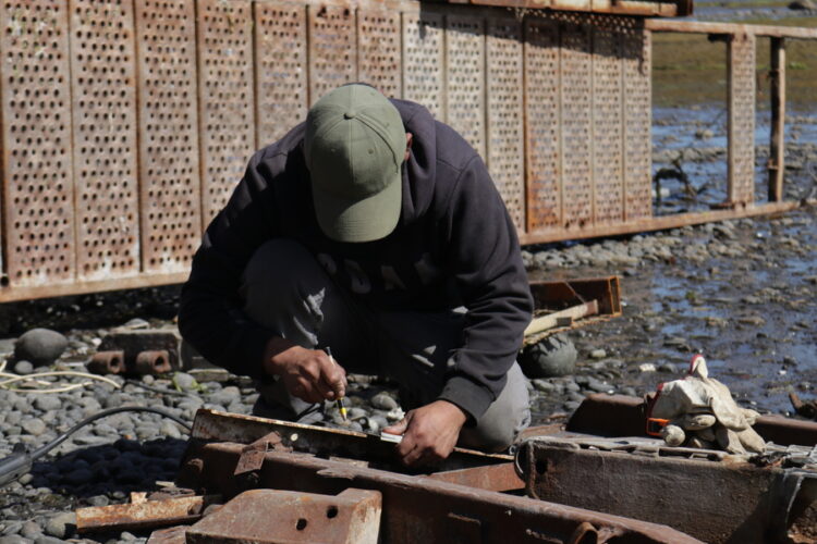 Trabajador realiza labores manuales en una zona costera de la Región de Los Lagos