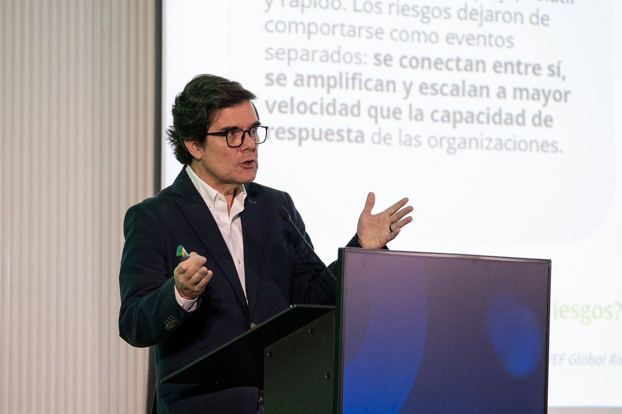 Ernesto Escobar exponiendo sobre tendencias de riesgos estratégicos en el centro de convenciones de Deloitte en Santiago.