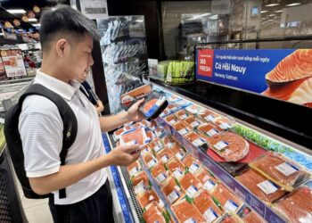 Consumidora observa salmón noruego en un supermercado de Vietnam