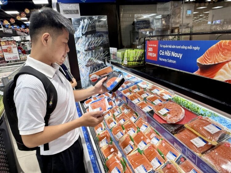 Consumidora observa salmón noruego en un supermercado de Vietnam