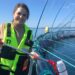 La investigadora Lisa-Victoria Bernhardt muestra el recipiente de un litro utilizado para tomar muestras de agua en jaulas noruegas.