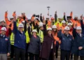 Trabajadores y autoridades con cascos levantan los brazos en una obra pública en Magallanes durante el plan Chile Despega