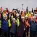 Trabajadores y autoridades con cascos levantan los brazos en una obra pública en Magallanes durante el plan Chile Despega