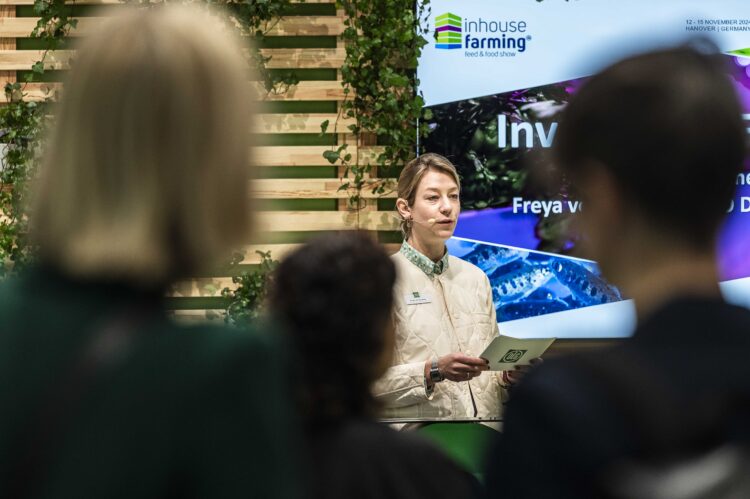 Expositora frente a asistentes en el escenario de Inhouse Farming durante EuroTier 2024.