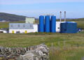 Planta de harina de pescado con estanques azules en Bressay, Escocia.