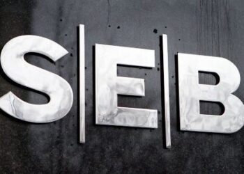 Logotipo de SEB en letras metálicas sobre una pared oscura.