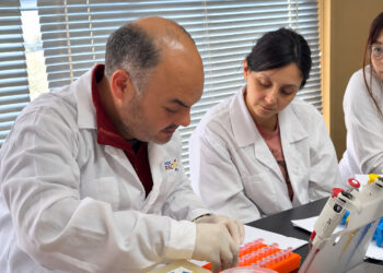 Investigadores y estudiantes de postgrado trabajando en laboratorio de biotecnología y patología acuícola.