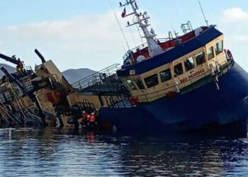 Wellboat Vali escorado y semihundido en aguas cercanas a Melinka con la popa bajo el mar.